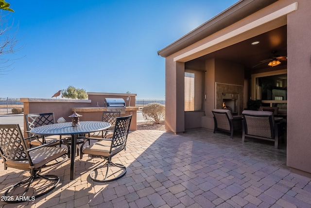 view of patio with an outdoor fireplace and exterior kitchen