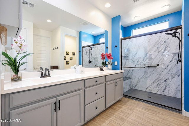 19560 W Valle Vista Way, Litchfield Park, AZ 85340 - full bathroom with double vanity, visible vents, a marble finish shower, and a sink