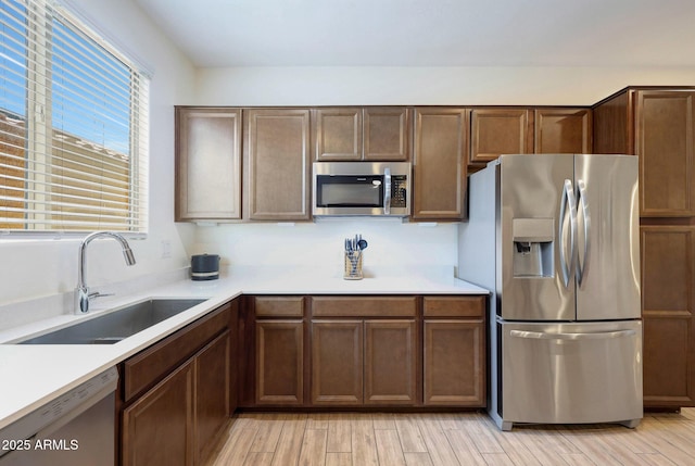 19560 W Valle Vista Way, Litchfield Park, AZ 85340 - kitchen featuring light countertops, light wood-type flooring, stainless steel appliances, and a sink