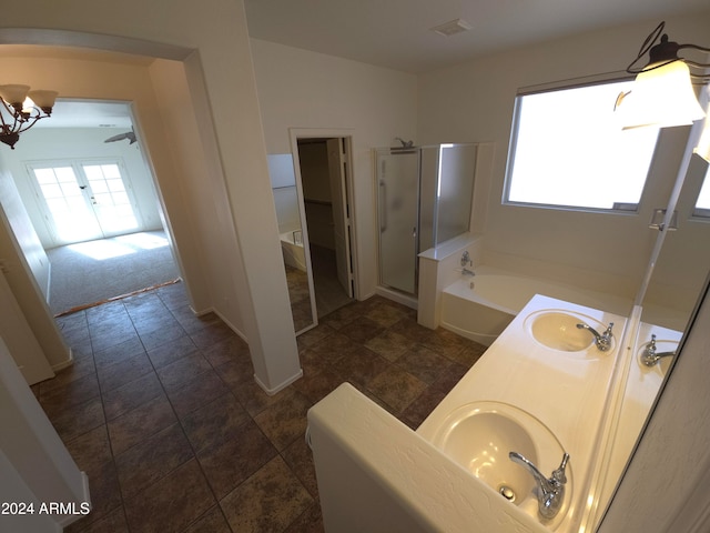 bathroom with shower with separate bathtub, an inviting chandelier, tile patterned floors, and sink