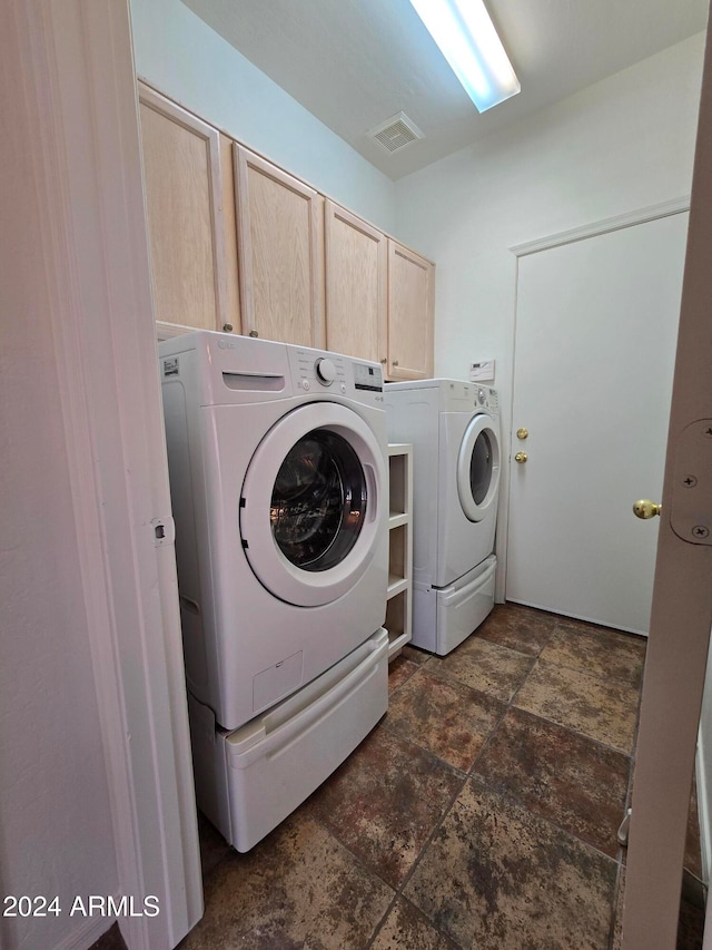 washroom with washer and clothes dryer and cabinets