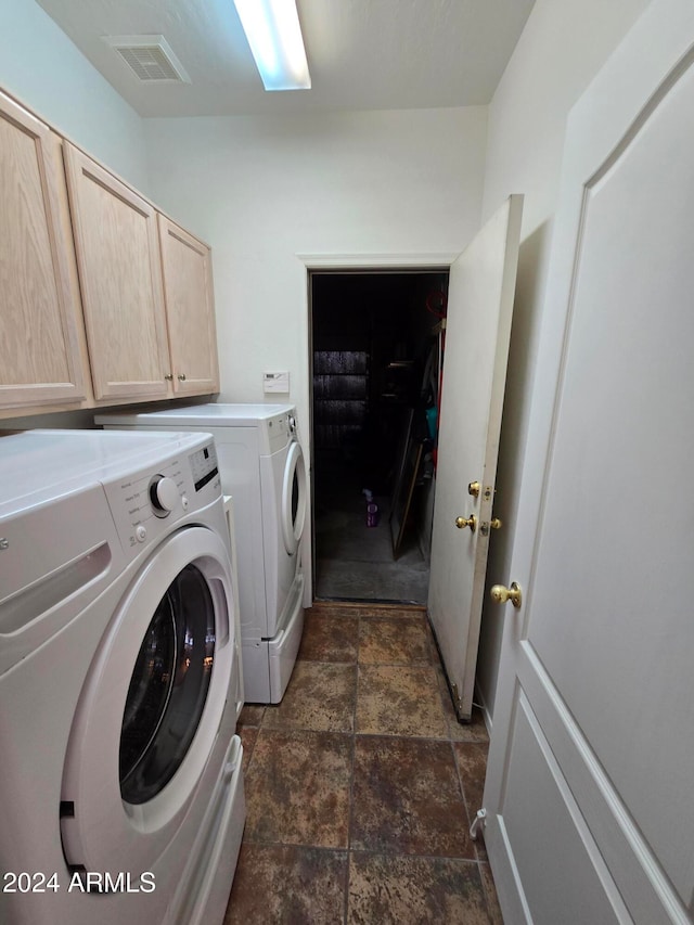 clothes washing area featuring washer and clothes dryer and cabinets