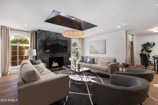 living room featuring recessed lighting, a high end fireplace, and wood finished floors