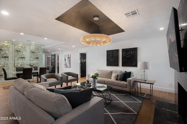 living area featuring baseboards, recessed lighting, wood finished floors, and visible vents