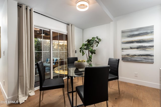 dining space featuring baseboards and wood finished floors