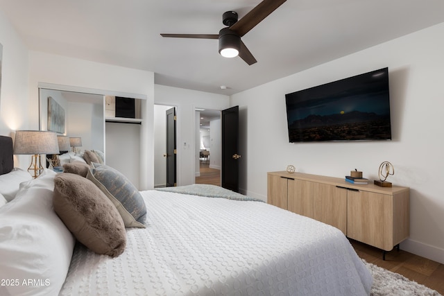 bedroom featuring baseboards, a ceiling fan, wood finished floors, and a closet