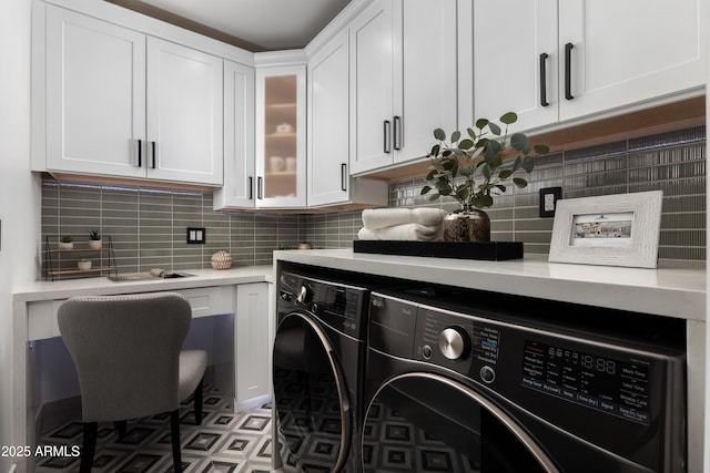 clothes washing area with cabinet space, tile patterned floors, and washer and dryer