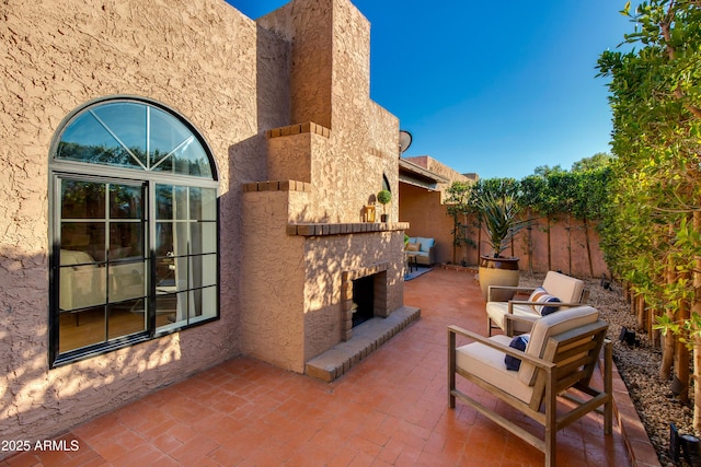 view of patio / terrace featuring an outdoor stone fireplace and fence