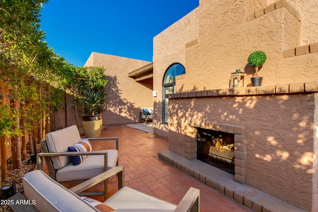 view of patio / terrace with grilling area and a warm lit fireplace