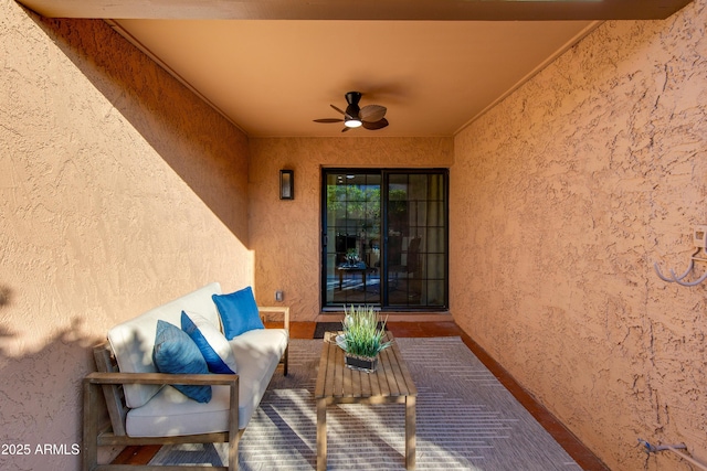 entrance to property featuring a ceiling fan, a patio area, stucco siding, and an outdoor hangout area