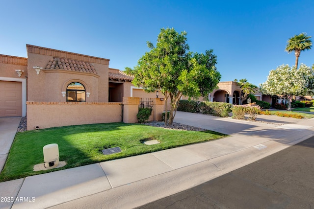 mediterranean / spanish-style home with a tiled roof, driveway, a front yard, fence, and stucco siding