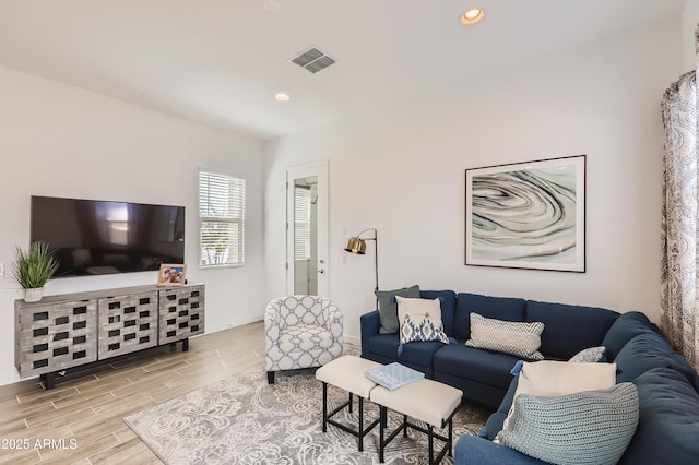 living area featuring wood tiled floor, visible vents, baseboards, and recessed lighting