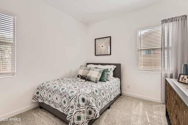 bedroom with light carpet and baseboards