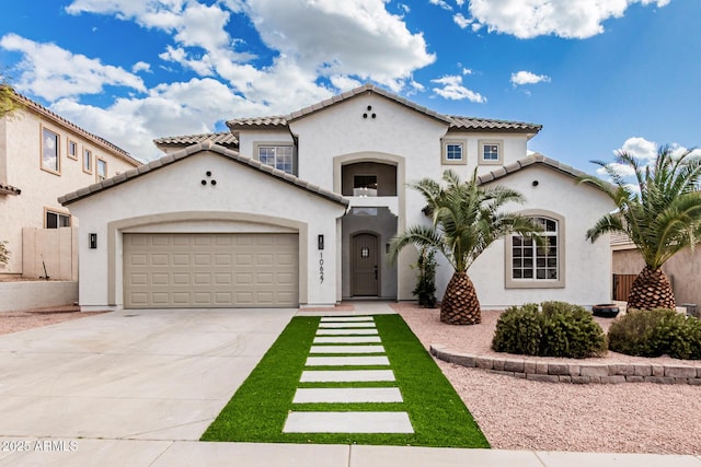 mediterranean / spanish house featuring driveway, an attached garage, a tiled roof, and stucco siding