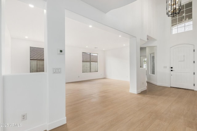 foyer entrance with recessed lighting, light wood-style flooring, baseboards, and an inviting chandelier