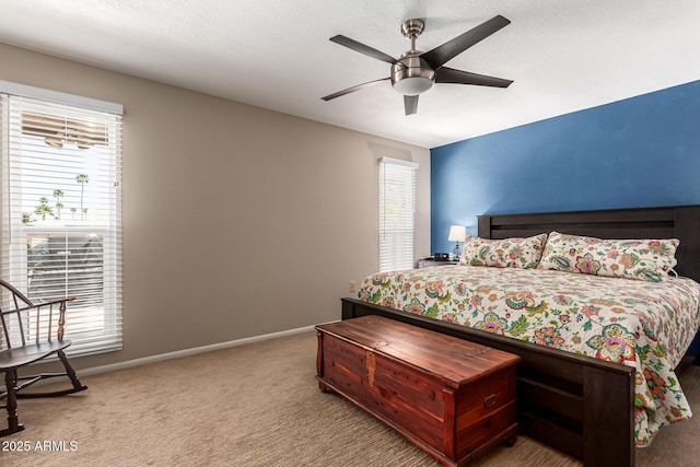 bedroom with baseboards, ceiling fan, carpet floors, and multiple windows