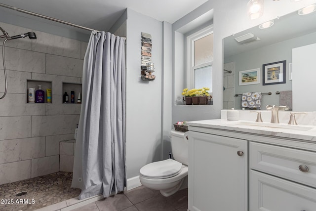 full bath with toilet, a tile shower, tile patterned flooring, and vanity