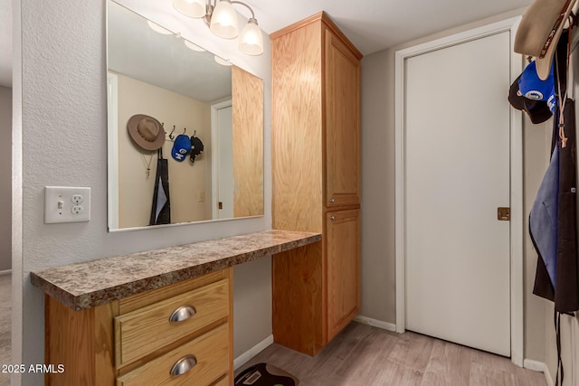 bathroom with wood finished floors, vanity, and baseboards