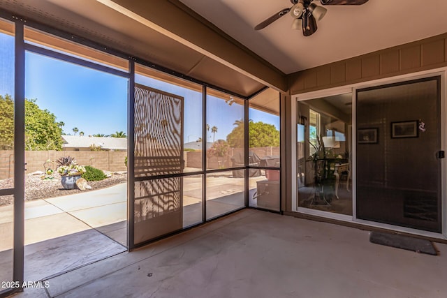 unfurnished sunroom featuring ceiling fan