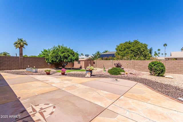view of patio featuring an outdoor structure, a storage shed, and a fenced backyard