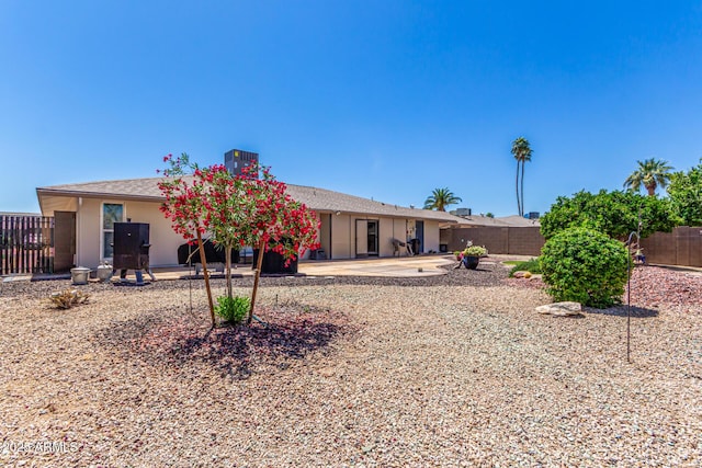 rear view of house with a patio and a fenced backyard