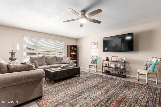 carpeted living room featuring baseboards, a ceiling fan, and a textured ceiling