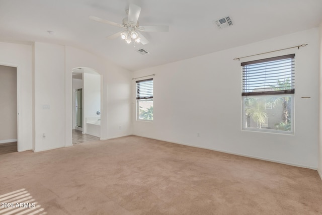 spare room with light carpet, lofted ceiling, and ceiling fan