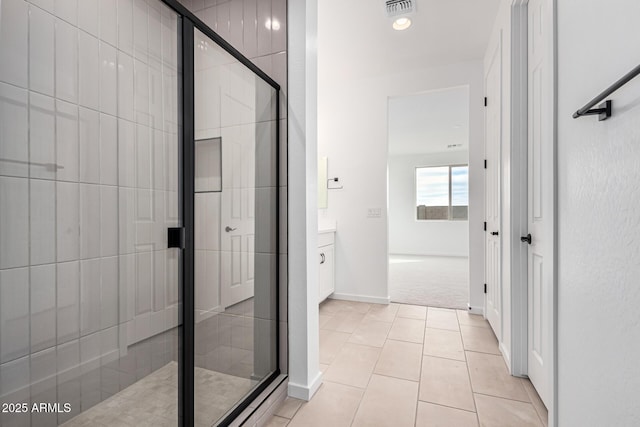 bathroom featuring tile patterned flooring, vanity, and an enclosed shower