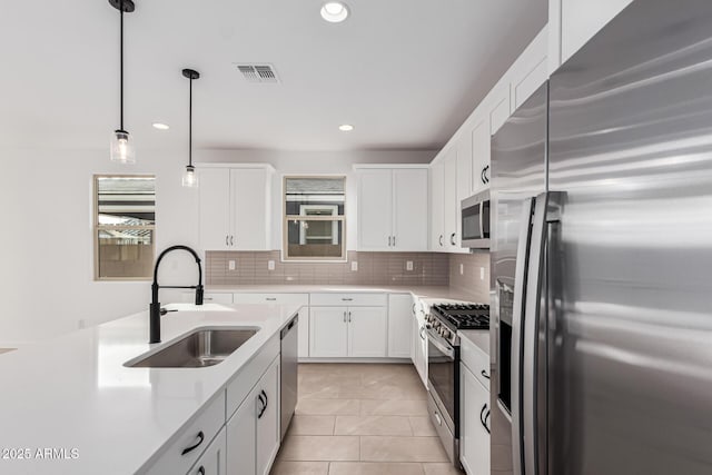 kitchen with white cabinetry, appliances with stainless steel finishes, sink, and pendant lighting