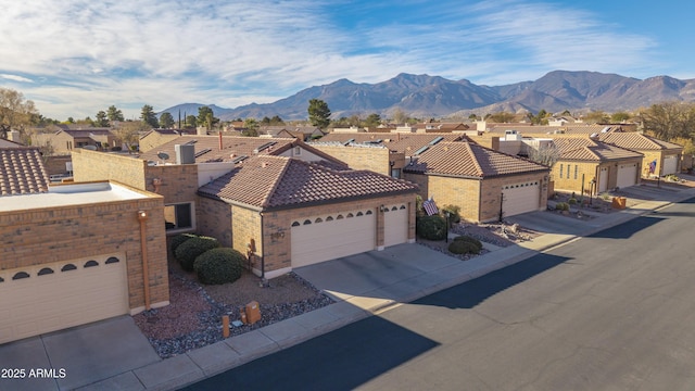 ranch-style house with a garage, a residential view, a mountain view, and a tiled roof