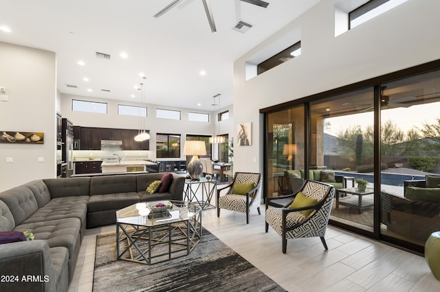 living room with a high ceiling and ceiling fan