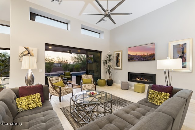 living room with ceiling fan and a high ceiling