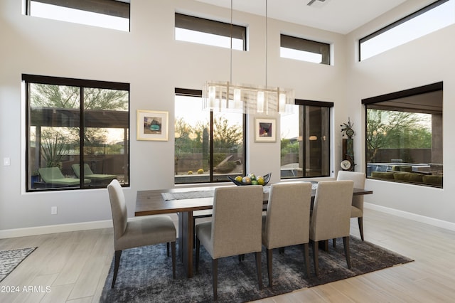 dining space featuring hardwood / wood-style flooring and a towering ceiling