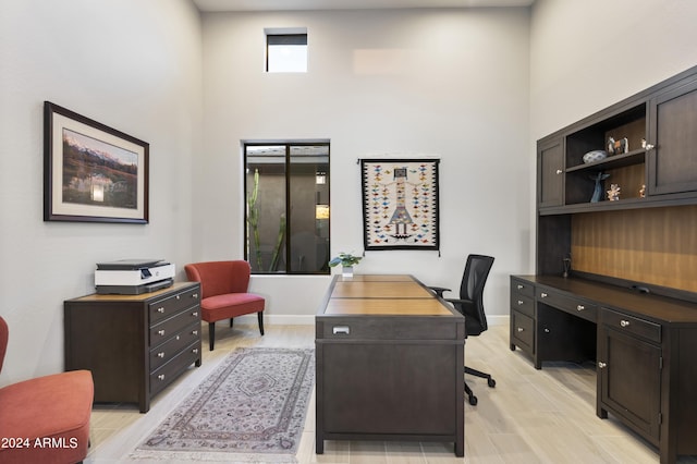 office area featuring a high ceiling and light wood-type flooring