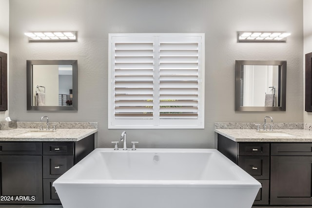 bathroom featuring vanity and a tub