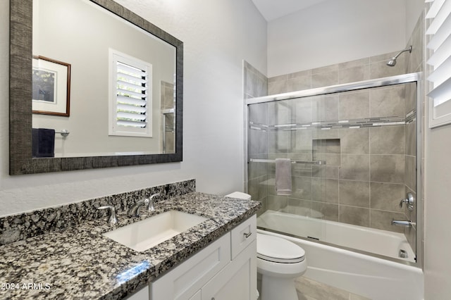 full bathroom featuring shower / bath combination with glass door, vanity, and toilet