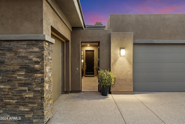 exterior entry at dusk with a garage