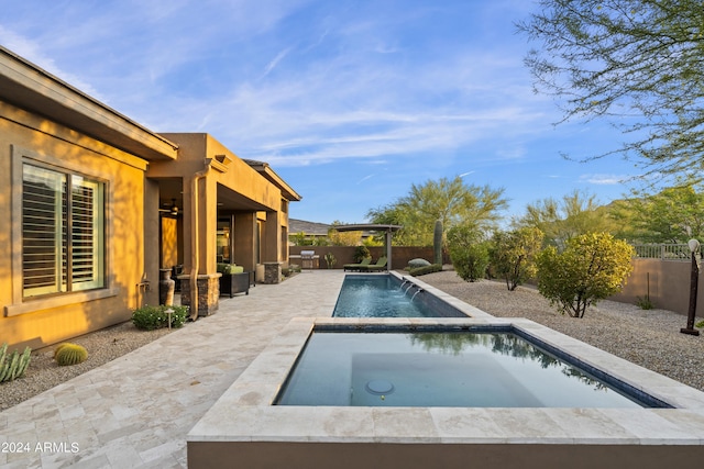 view of swimming pool featuring an in ground hot tub, pool water feature, and a patio area