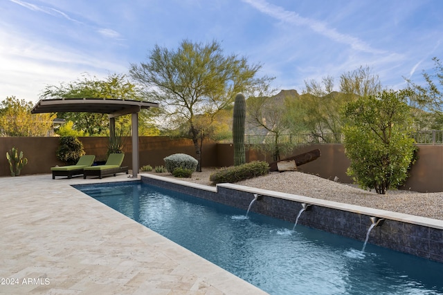 view of swimming pool with pool water feature and a patio