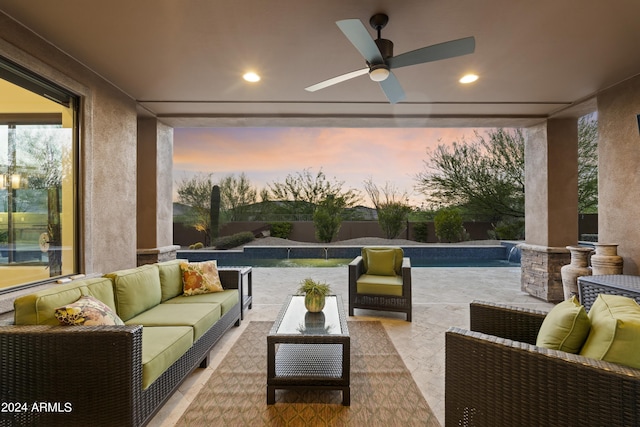 patio terrace at dusk with pool water feature, ceiling fan, and an outdoor hangout area