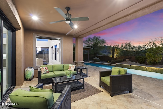 patio terrace at dusk with outdoor lounge area, a fenced in pool, and ceiling fan