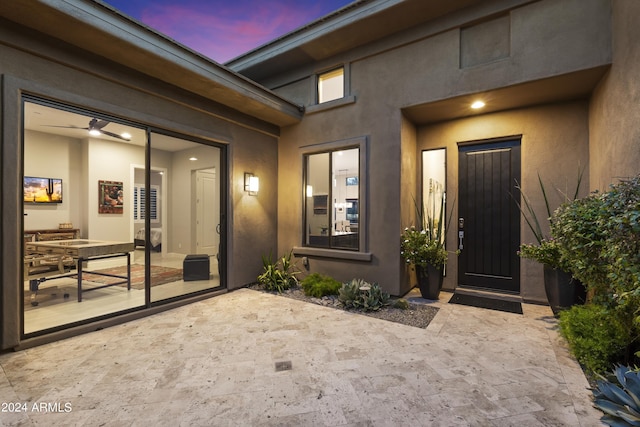 exterior entry at dusk featuring a patio