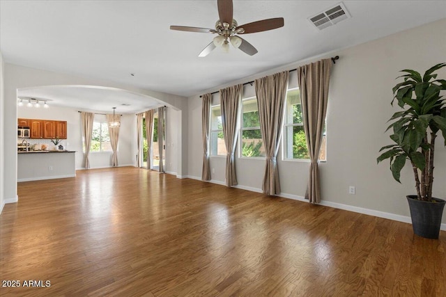 3784 E Washington Ct, Gilbert, AZ 85234 - unfurnished living room featuring arched walkways, a ceiling fan, wood finished floors, and baseboards