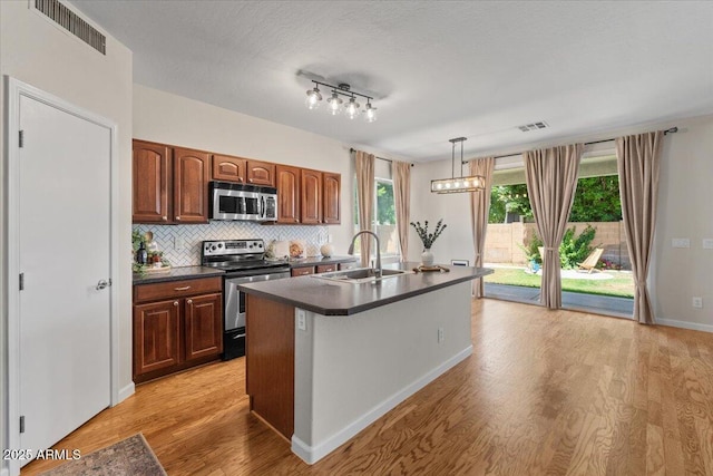 3784 E Washington Ct, Gilbert, AZ 85234 - kitchen with a sink, stainless steel appliances, dark countertops, light wood-type flooring, and backsplash