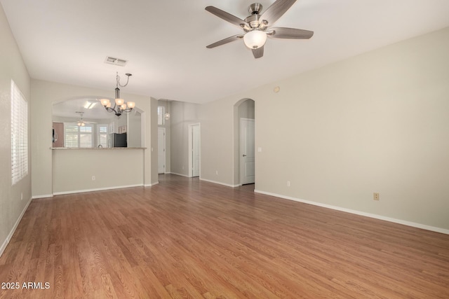 20632 N 103rd Ave, Peoria, AZ 85382 - unfurnished living room featuring arched walkways, a chandelier, ceiling fan, and wood finished floors