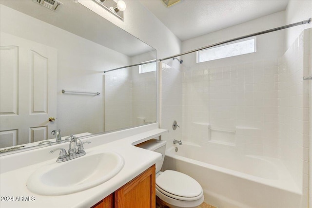 full bathroom featuring vanity, tiled shower / bath combo, and toilet