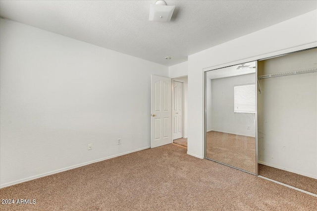 unfurnished bedroom featuring a closet, carpet, and a textured ceiling