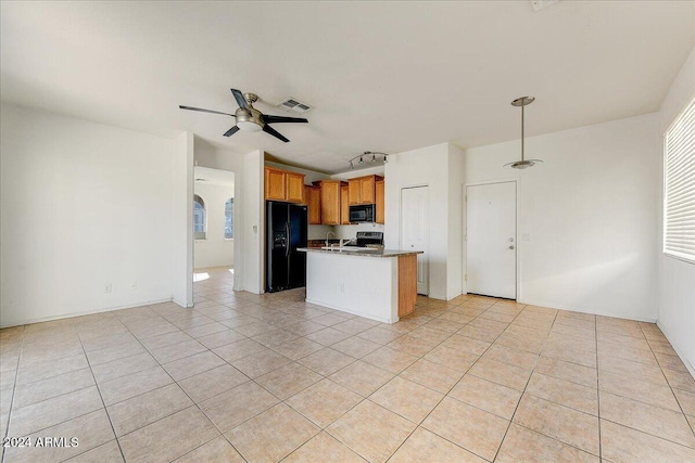 kitchen featuring ceiling fan, sink, black appliances, light tile patterned floors, and an island with sink