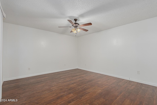 spare room featuring ceiling fan, dark wood-type flooring, and a textured ceiling