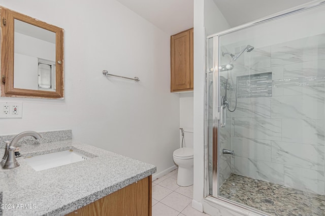 bathroom with toilet, vanity, a shower with door, and tile patterned flooring